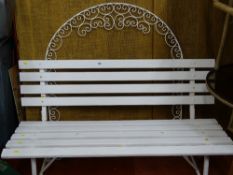 White painted wooden slatted garden bench and a wrought iron white painted arch having scrolled