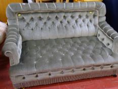 Neat button upholstered two seater salon couch on ebonized supports and black pot castors, circa