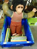 Plastic crate of Ladybird and other children's books along with a soft toy monkey