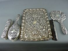 Silver embossed mask decorated dressing table tray and four piece mirror and brush set with