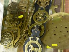 Wicker basket with horse brasses contents, leather strap of horse brasses and other brassware