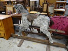 A vintage mottled grey rocking horse on wooden stand Condition reports provided on request by