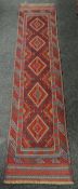 A rust and blue patterned Meshwani runner, 260 x 60cms Condition reports provided on request by