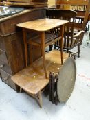 An Ercol lightwood two-tier Long John coffee table (distressed), a brass Benares folding table,