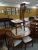 A modern circular / oval dining table and four chairs Condition reports provided on request by email