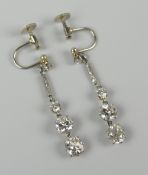 PAIR OF GRADUATED DIAMOND DROP EARRINGS having small diamond above diamond chip bar above three