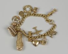 18CT YELLOW GOLD CURB LINK CHARM BRACELET having an assortment of 9ct gold charms to include a cased
