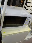 Whirlpool fridge freezer, a white coloured 700w compact microwave oven and an invalid seat E/T