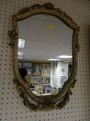 Neat shield shaped floral and scroll decorated wall mirror, 39 x 26 cms maximum
