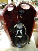 Baker Professional microscope with revolving lens carrier in a bakelite folding hinged case