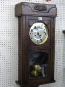 Polished encased pendulum wall clock with silvered dial