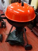 Red topped kettle BBQ with utensils and outdoor cover