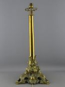 A CIRCA 1900 BRASS TABLE LAMP and tasselled shade, the capped circular column with pierced Rococo
