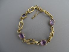 A NINE CARAT GOLD DOUBLE LINK BRACELET with four oval cut topaz, 9.3 grms gross