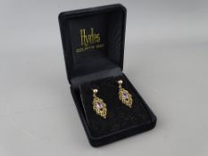 A PAIR OF BELIEVED GOLD OVAL SCROLLED EARRINGS with centre purple stone, 2.5 grms gross
