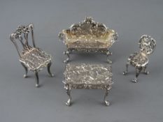 A FOUR PIECE SILVER MINIATURE FURNITURE SET of table, couch and two chairs, Birmingham 1962, maker
