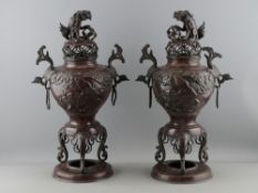 A PAIR OF 19th CENTURY JAPANESE BRONZE SENSORS having temple dog with ball finial covers, relief