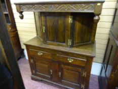 A REPRODUCTION OAK BUFFET SIDEBOARD with carved top frieze and fancy brass 'H' hinges, 148 cms high,
