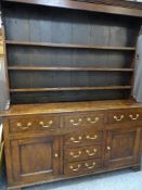 A CIRCA 1830 NORTH WALES ANGLESEY OAK DRESSER, the three shelf rack having shaped detail and wide