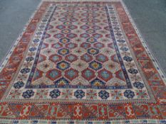 A GOOD EASTERN MULTI-PATTERNED CARPET on a rust and cream ground, repeating central classical