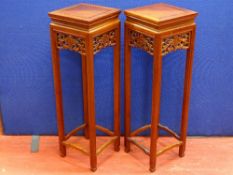 A PAIR OF 20th CENTURY CHINESE HARDWOOD STANDS with fruit and vine side decoration, 91.5 cms high,