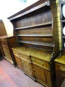 AN EARLY 19th CENTURY NORTH WALES OAK BREAKFRONT DRESSER, the shape sided three shelf rack over a