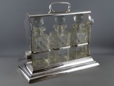 A WALKER & HALL SILVER PLATED THREE BOTTLE TANTALUS, the decanters and stoppers numbered 1, 2 and