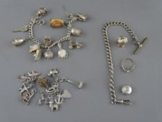 THREE SILVER & WHITE METAL CHARM BRACELETS with approximately twenty seven charms including a ten