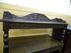 A VINTAGE OAK HALL BENCH having a shaped back and side rails with carved detail on block and