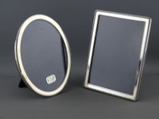 TWO MODERN HALLMARKED SILVER EASEL PHOTOGRAPH FRAMES to include a 20.5 x 15.5 cms oval, Sheffield