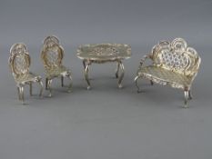 A FOUR PIECE LATTICE WORK SILVER MINIATURE FURNITURE SET of table, couch and two chairs, import