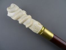 A CARVED SECTIONAL BONE TOP WALKING CANE in the form of a hand gripping a coiled serpent, the cane