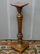 A PROBABLY FRENCH WALNUT TURNED & REEDED COLUMN STAND with pink marble square top, 113 cms high,
