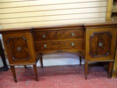 A SHERATON STYLE MAHOGANY INVERTED BREAKFRONT SIDEBOARD having twin central drawers over a