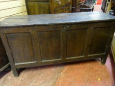 AN ANTIQUE OAK COFFER with panelled front on stile feet, 65 cms high, 123.5 cms wide, 46.5 cms deep