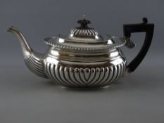 A VICTORIAN SILVER TEAPOT with gadrooned decoration, composite handle and lid finial, Birmingham