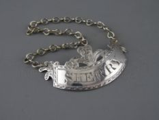 A GEORGE III SILVER SHERRY LABEL, crescent shaped with Prince of Wales plumes, London 1811, maker