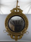 A REGENCY CONVEX BOBBLE WALL MIRROR with entwined fish surmount, twin candle sconce arms and lower