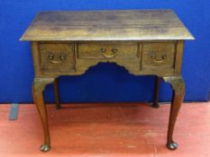 AN 18th CENTURY OAK THREE DRAWER LOWBOY on cabriole supports and pad feet, 69 cms high, 83 cms wide,