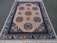 A CHINESE KAYAM WOOL PILE CARPET, deep blue Oriental style pattern on a pink ground with spandrel