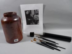 A BLACK & WHITE PHOTOGRAPH OF MOSS WILLIAMS at work together with the circular ironstone pot shown