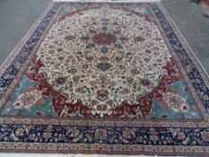 A LARGE PERSIAN STYLE LEAF & FLORAL PATTERNED CARPET, the central cartouche in cream and rust