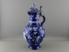 AN EXCELLENT GERMAN STONEWARE JUG, the metal mounted thumb lift lid with gnome type figure finial