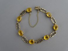A NINE CARAT GOLD LINK BRACELET with seven alternating oval citrines, 11.5 grms gross