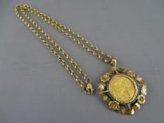 A 1915 FULL GOLD SOVEREIGN set in a leaf and floral nine carat gold mount, on a 24 ins nine carat