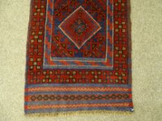 A MESHWANI CARPET RUNNER, red ground with block pattern border and repeating diamond central