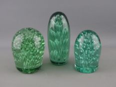 THREE VICTORIAN GREEN GLASS DUMP PAPERWEIGHTS, all in stand-up form with bubble inclusions, 15 cms