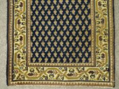AN OLD PERSIAN CARPET RUNNER, blue and cream ground with central repeating pattern and wide