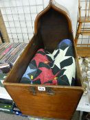 Antique mahogany hooded cradle/crib containing a patchwork bed cover, (no rockers to the cradle)