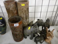 Three carved cylindrical bamboo pots, a quantity of carved ebony elephant and other figurines and